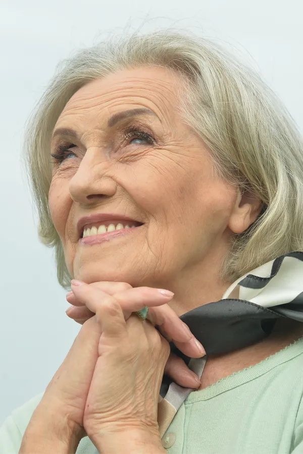 Hot-Flashes-and-Night-Sweats-Treatments An older woman holds her hands together under her chin and looks up at a cool sky smiling. Get treatment for hot flashes and night sweats from Stephen Beyer, DC in Mokena.