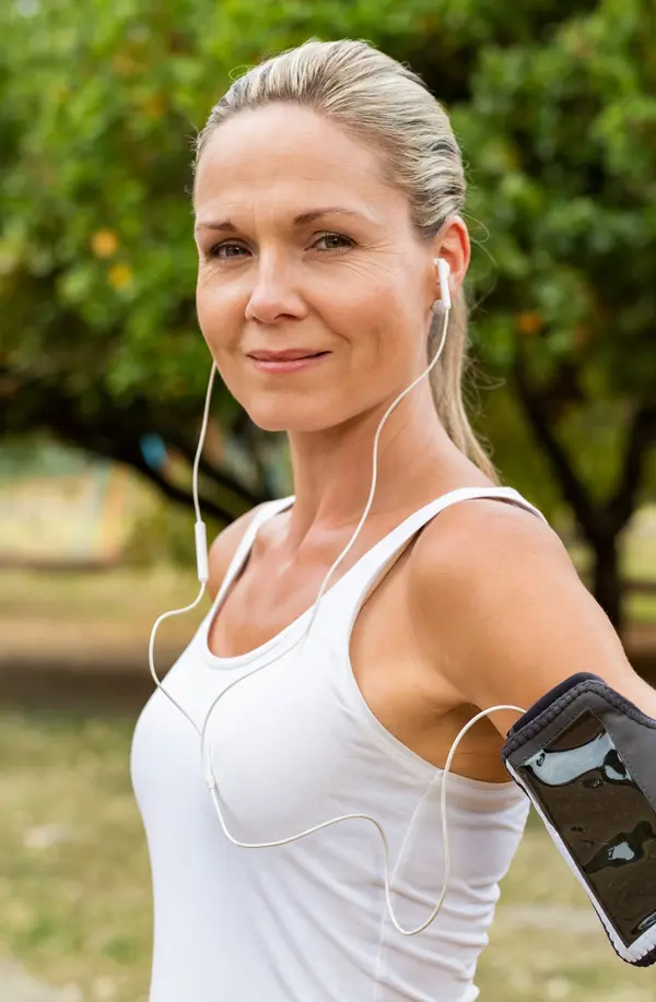 Insulin-Resistance-Treaatment A fit middle aged woman wearing earphones and a tank top smiles after a run. Get insulin resistance treatment from Stephen Beyer, DC in Mokena.