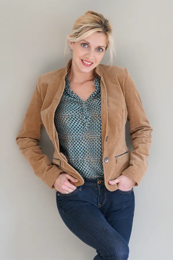 Metabolic-Syndrome-Treatment A smiling blonde woman in a tan leather jacket leans against a gray wall. Schedule metabolic syndrome from Stephen Beyer, DC in Mokena.