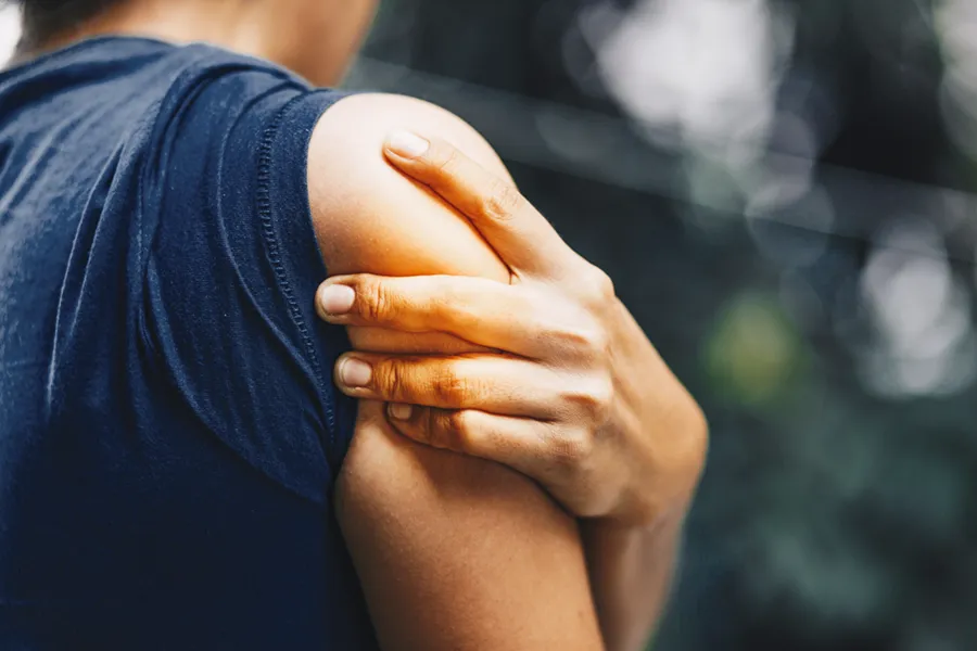 PRP-for-Shoulder-Injury-Doctor Close up of a woman in a tank top holding her shoulder in pain, which can be relieved by PRP treatment for shoulder pain from Stephen Beyer, DC in Mokena.