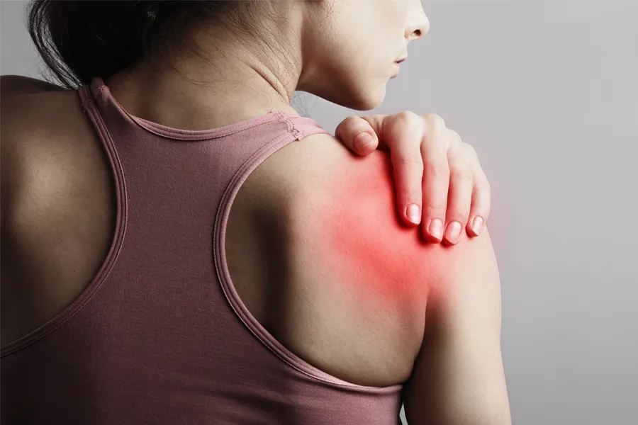 Rotator-Cuff-Clinic A woman holds her shoulder in pain. Get rotator cuff treatment from Stephen Beyer, DC in Mokena.