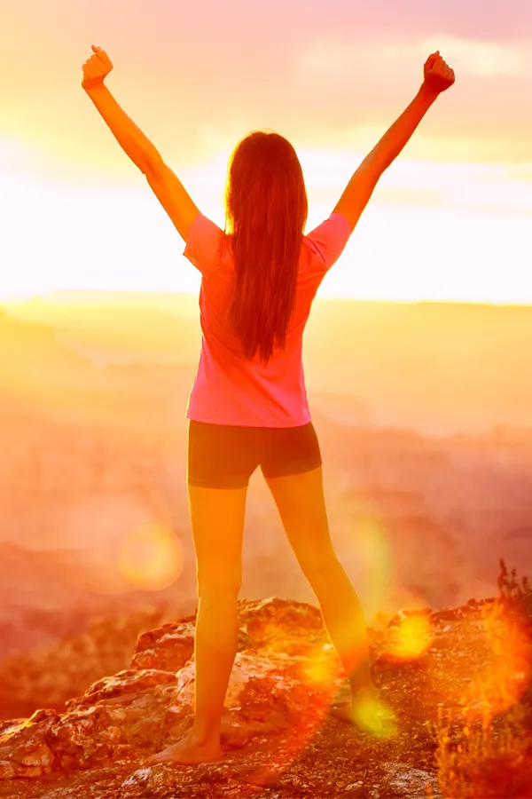 Rotator-Cuff-Treatment A woman raises her arms in triumph at sunrise. Get rotator cuff treatment from Stephen Beyer, DC in Mokena.