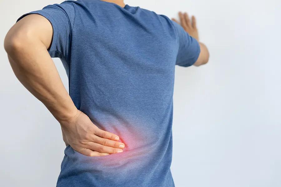 Sciatica-Clinic A man holds his back in pain. Schedule sciatica treatment from Stephen Beyer, DC in Mokena.
