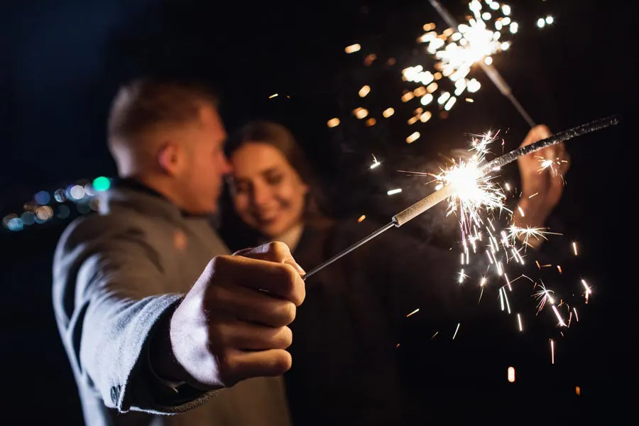 Shockwave-Doctor A couple in coats embrace and hold out sparklers at night, representing shockwave treatment for erectile dysfunction from Stephen Beyer, DC in Mokena.